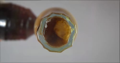 Dark Liquid Filling Bottle Close Up Abstract