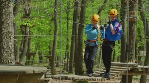 People Navigating Ropes Course High in the Trees