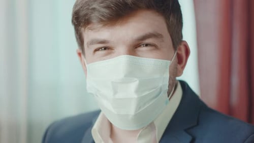 Smiling Man Wearing a Medical Mask Indoors