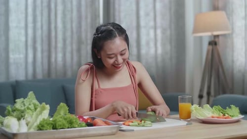 Young Woman Smiling Cutting Fresh Vegetables at Home