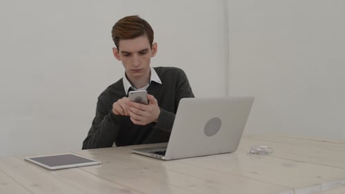 Young Adult Using Phone at Light Desk