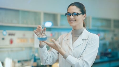 Woman Holding Blue Liquid in Laboratory