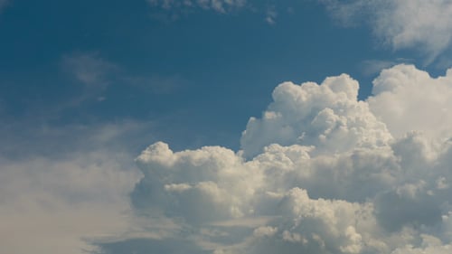 Clouds Slowly Moving Across a Blue Sky
