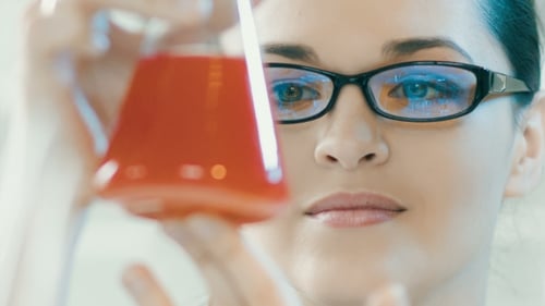 Scientist Inspecting Red Liquid in Beaker