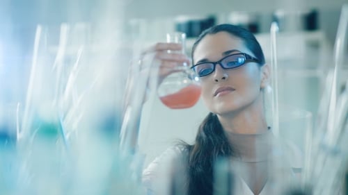 Female Scientist Inspecting Solution in Lab