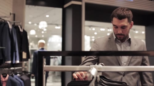 Young Man Choosing Suit In Clothing Store Or Mall 26