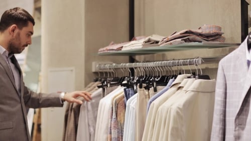 Jovem feliz escolhendo roupas na loja de roupas 4