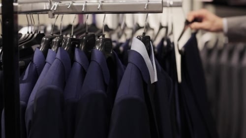 Young Man Choosing Clothes In Clothing Store 10