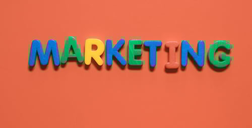 Colorful Letters Spell "Marketing" Against Orange Background