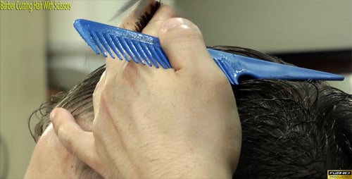 Peluquero cortando el pelo con tijeras