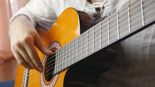 Manos tocando la guitarra acústica