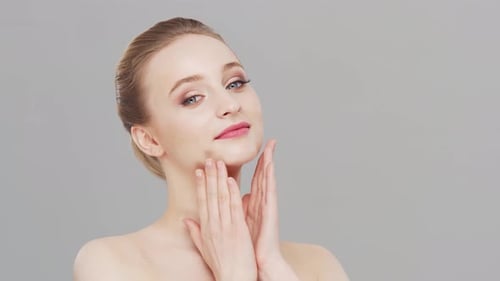 Studio portrait of young, beautiful and natural woman over grey background.