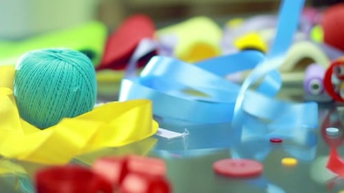 Colorful Ribbons Falling onto Craft Supplies
