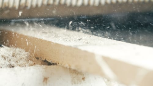 Saw Blade Cutting Wood Plank Close Up