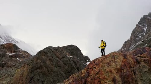 Tourist on Mountain Top. Sport and Active Life. Hiker with Backpack Standing on Top of a Mountain
