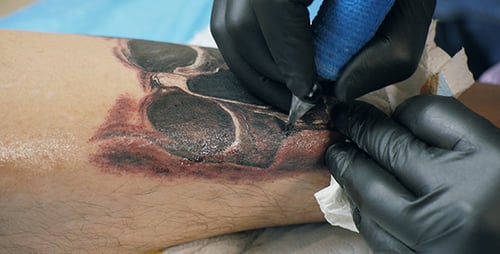 Skull Tattoo Being Etched on Calf
