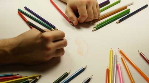 People Drawing Together with Colored Pencils on Paper