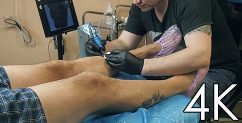 Tattoo Artist Working on Leg Tattoo in Studio