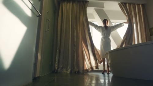 The Female Opens Curtains On a Window