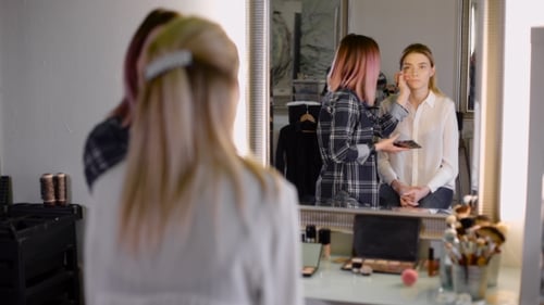 Makeup Artist Applying Makeup in Bright Studio