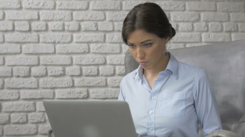 Woman Working on Laptop in Bright Home Office