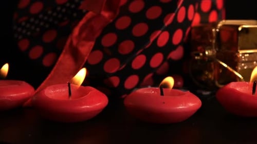 Burning Candles Next to Holiday Gifts at Night