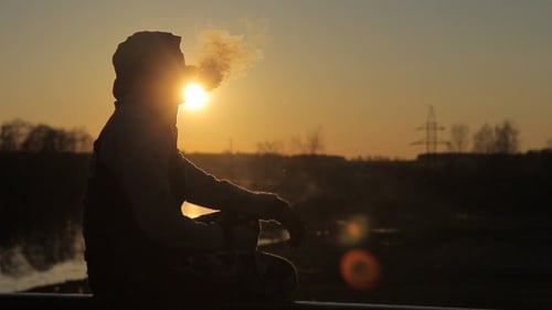 Man in profile,Sunset, Smoking Electronic Cigarette