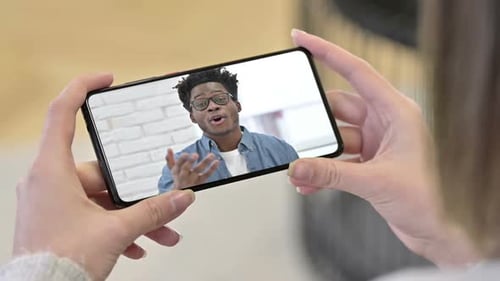 Sprechen junger afrikanischer Mann im Smartphone während des Videochats
