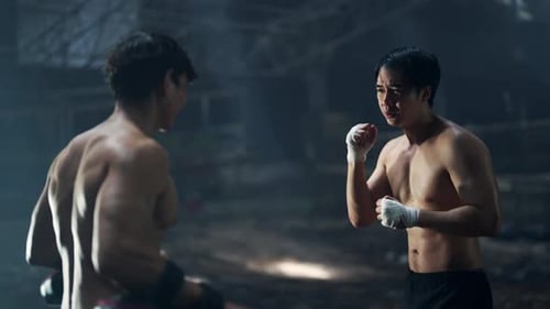 4K Asian man boxer do practicing boxing with male coach in abandoned building.