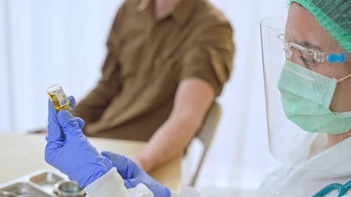 Medical Worker Preparing Syringe at Hospital