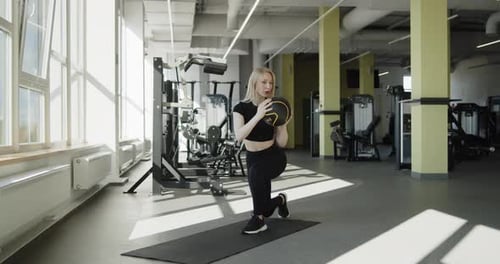 Young Active Athletic Blonde Girl Works Out in the Gym