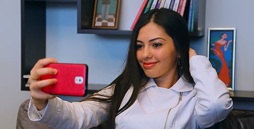 Woman Takes Selfie with Phone in Home