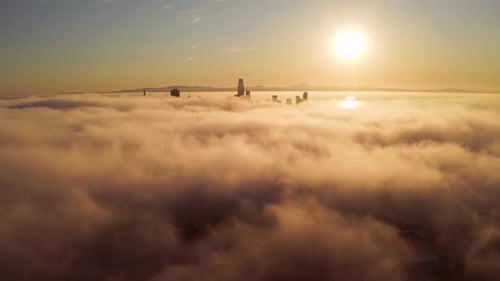 Golden City Skyline Emerging From Fog At Sunrise