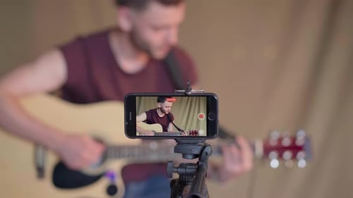 Man Plays Guitar While Recording on Phone
