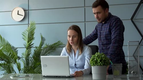 Office Colleagues Reviewing Data on Laptop Screen
