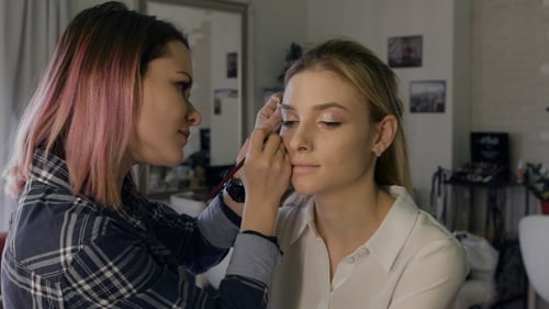 Woman Applying Makeup to Friend's Face