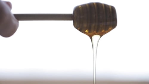 Hand Holding Dipper With Pouring Honey 7