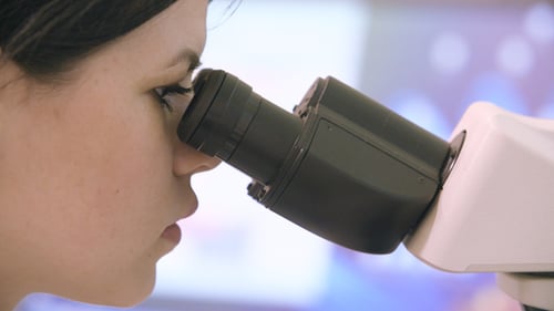 View of Young Doctor Looking Through Microscope