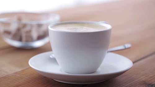 Milk Being Poured Into Cup of Coffee