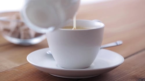 Cream Pouring To Coffee Cup On Wooden Table 10