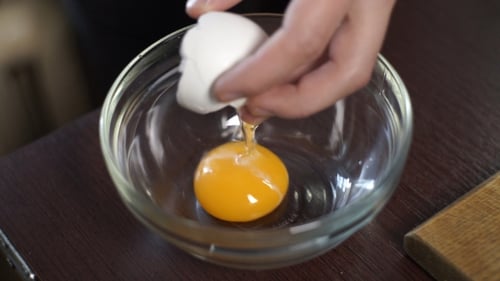 Cracking a Fresh Egg into a Clear Bowl