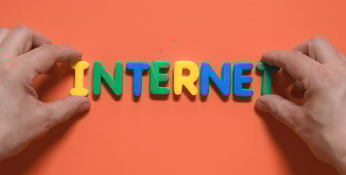 Hands Spelling Internet with Block Letters on Orange