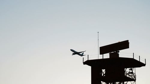 Flugzeug und Radarturm bei Sonnenuntergang