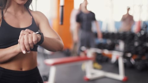 Smart Watch Showing a Heart Rate Of Exercising Woman In Gym