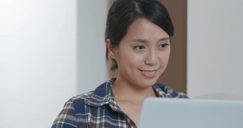 Woman Works at Laptop Computer Indoors