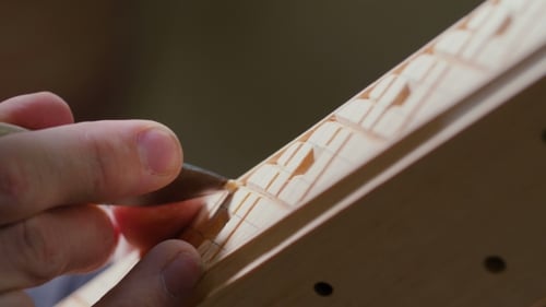 Woodworker Carving Intricate Design into Wooden Piece