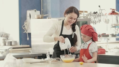 Woman and Girl Joyfully Baking Together in Kitchen