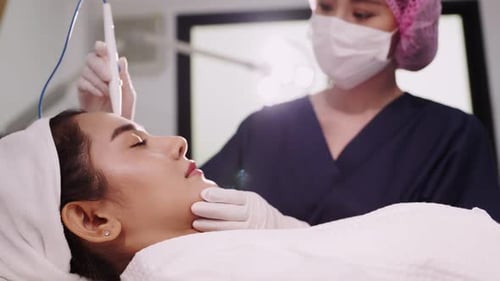 Beauty clinic concept. Young woman getting professional facial procedure.