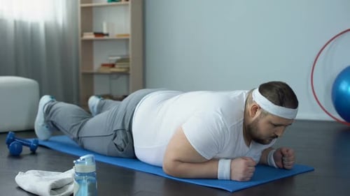 Man Doing Plank Exercise on Mat at Home