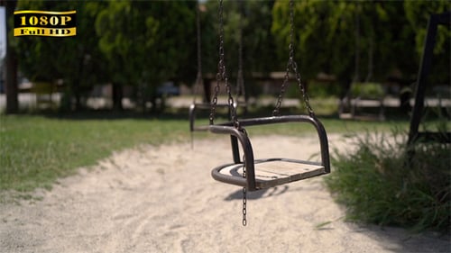 Park Swing Set Gently Swaying on Sunny Day